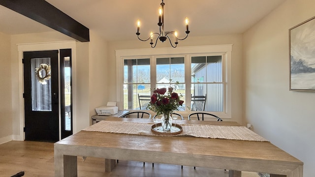 dining room with wood finished floors, a notable chandelier, and beamed ceiling