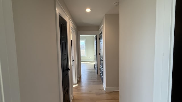 corridor featuring light wood-style floors, recessed lighting, and baseboards