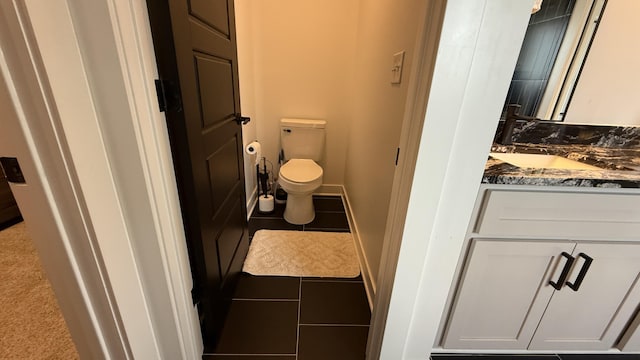 bathroom with baseboards, vanity, toilet, and tile patterned floors