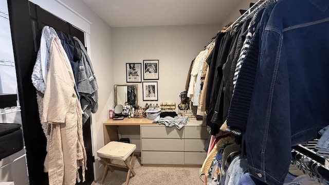 walk in closet featuring light carpet