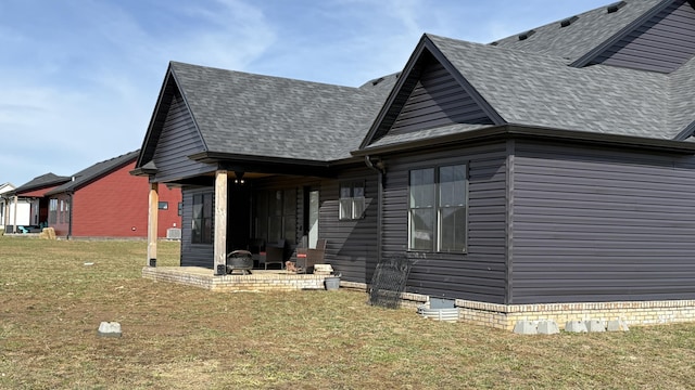 exterior space with a patio area, a front lawn, and a shingled roof