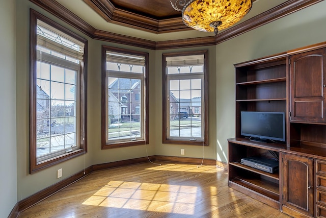 interior space featuring baseboards, light wood-type flooring, and crown molding