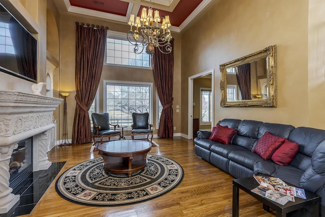 living room with a wealth of natural light, baseboards, crown molding, and wood finished floors