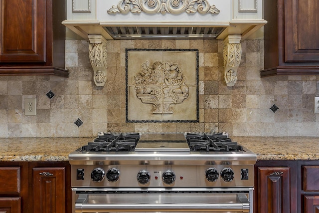 kitchen with tasteful backsplash, exhaust hood, high end range, and light stone countertops