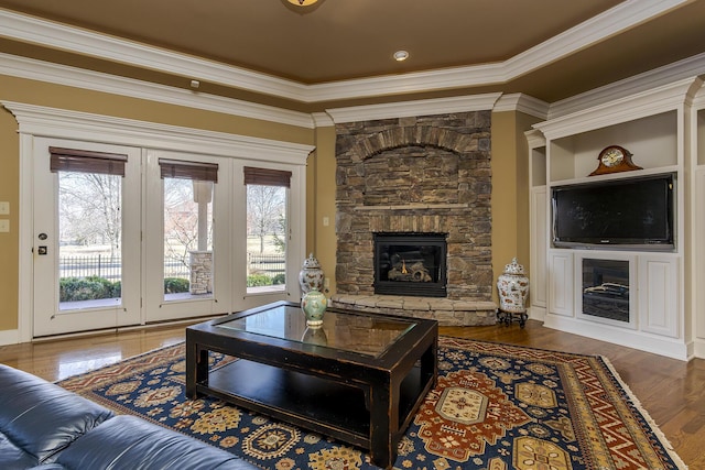 living room with ornamental molding, a fireplace, and wood finished floors