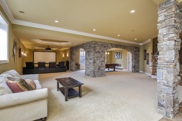 carpeted living room featuring visible vents, arched walkways, ornamental molding, ornate columns, and recessed lighting