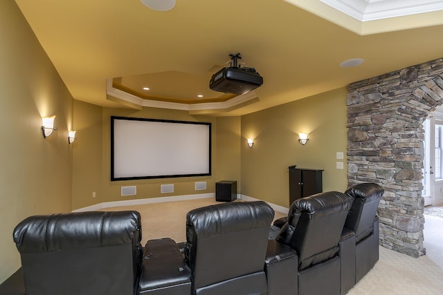 cinema with light carpet, baseboards, a tray ceiling, and crown molding