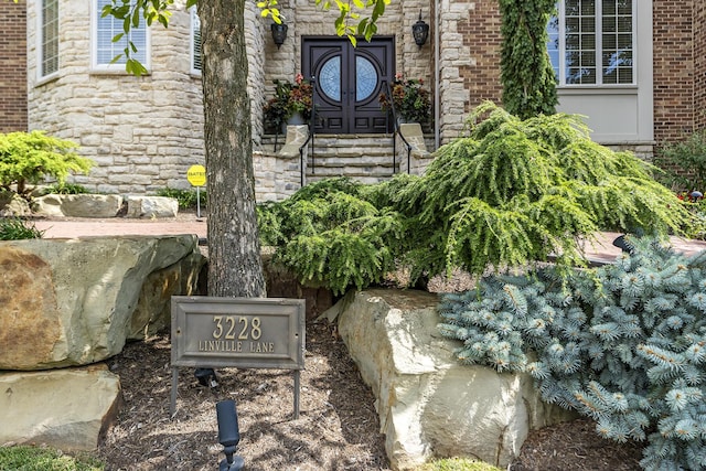 exterior details featuring stone siding and brick siding