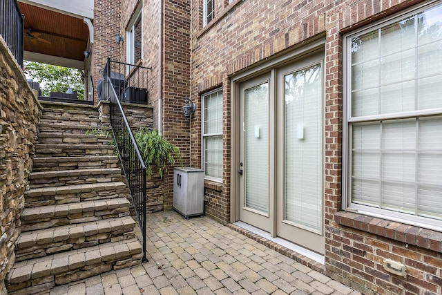 doorway to property with brick siding and a patio