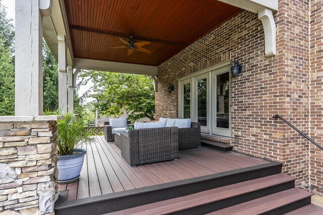 wooden terrace with outdoor lounge area and a ceiling fan