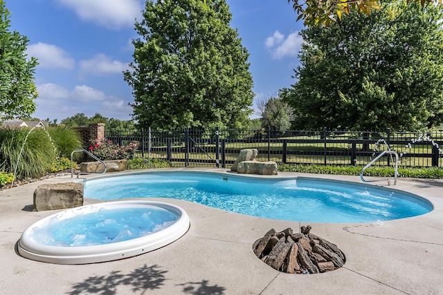 view of swimming pool with a patio, fence, a fenced in pool, and an in ground hot tub