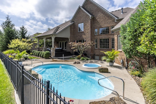 view of swimming pool with an in ground hot tub, fence, a fenced in pool, and a patio