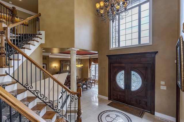 entryway with a high ceiling, baseboards, stairway, decorative columns, and an inviting chandelier