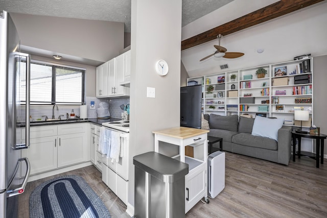 kitchen featuring white electric range, wood finished floors, a sink, and white cabinets