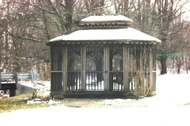 snow covered structure with a sunroom