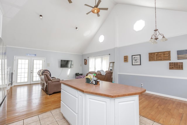 kitchen featuring a center island, pendant lighting, light wood finished floors, open floor plan, and white cabinetry