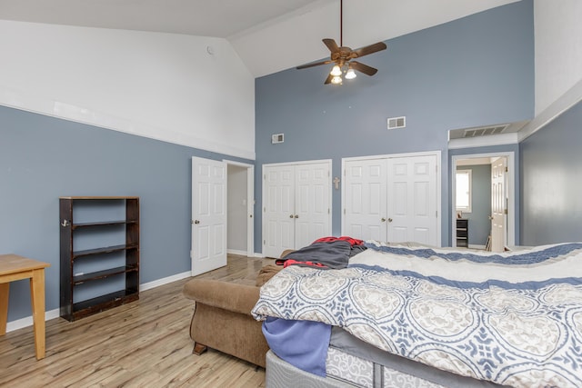 bedroom with light wood-type flooring, visible vents, baseboards, and two closets