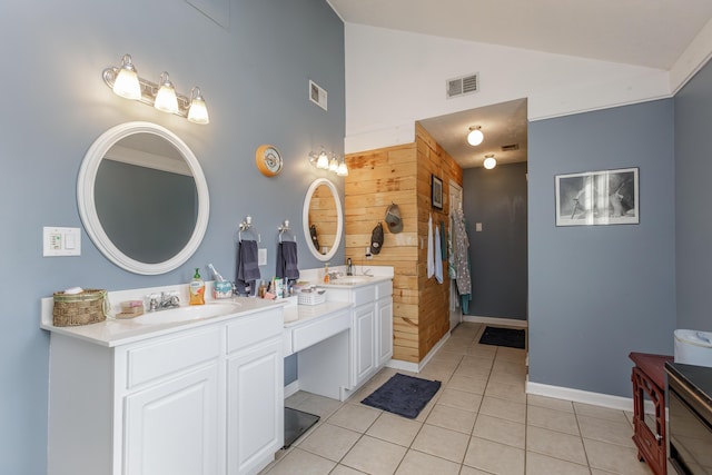 bathroom featuring double vanity, visible vents, vaulted ceiling, a sink, and tile patterned floors