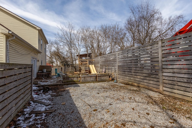 view of yard with a fenced backyard and a playground