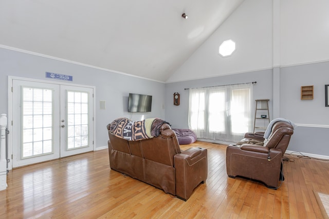 living area with high vaulted ceiling, light wood-style flooring, baseboards, ornamental molding, and french doors