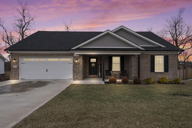 view of front of house with a garage, a front yard, concrete driveway, and brick siding