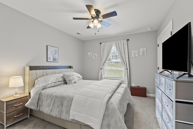 bedroom with light carpet, visible vents, baseboards, and a ceiling fan