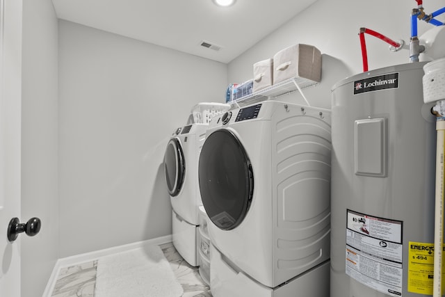 washroom with laundry area, baseboards, marble finish floor, washer and dryer, and water heater