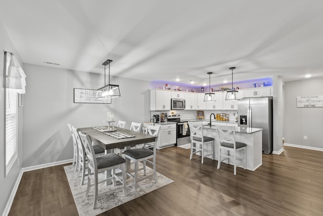 dining area featuring visible vents, baseboards, and dark wood finished floors