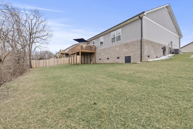 back of house featuring cooling unit, brick siding, fence, crawl space, and a lawn