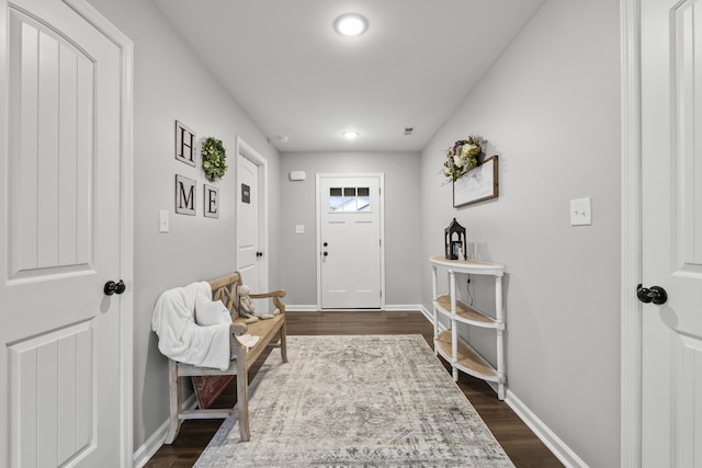 foyer entrance with baseboards and dark wood-style flooring