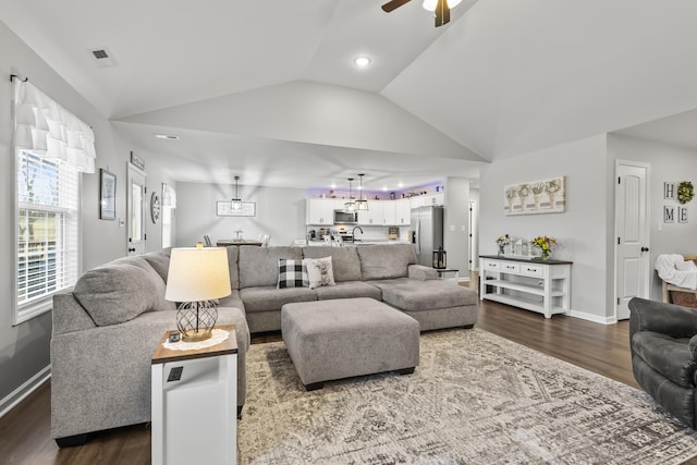 living room featuring baseboards, visible vents, lofted ceiling, ceiling fan, and dark wood-type flooring