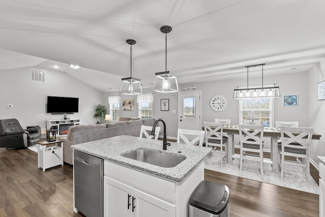 kitchen featuring light stone counters, a sink, visible vents, white cabinetry, and stainless steel dishwasher