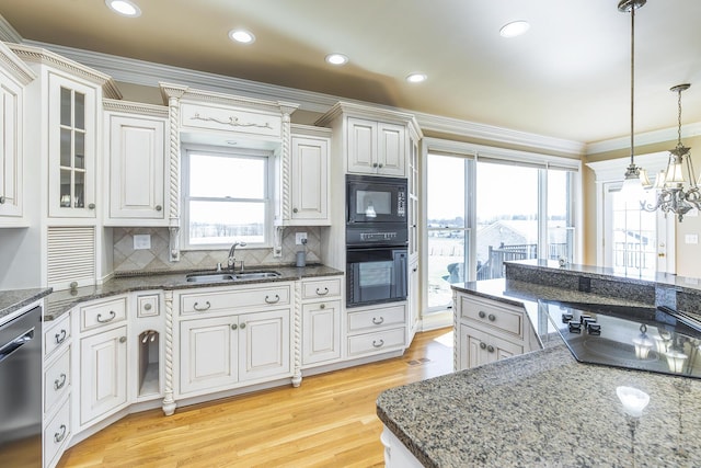 kitchen featuring ornamental molding, a sink, light wood-type flooring, black appliances, and an inviting chandelier