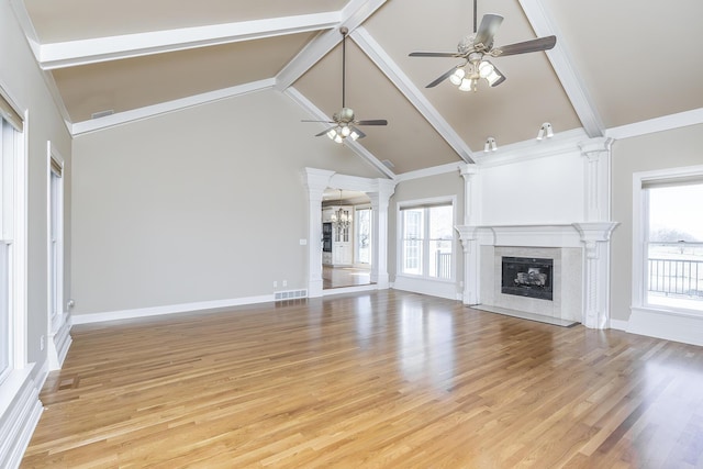 unfurnished living room with decorative columns, a high end fireplace, beam ceiling, and ceiling fan