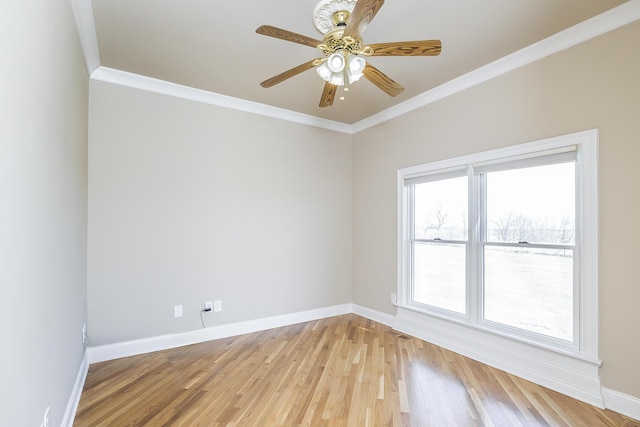 spare room featuring baseboards, light wood-style flooring, ornamental molding, and a ceiling fan