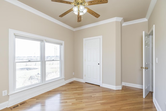 unfurnished bedroom featuring baseboards, visible vents, ornamental molding, and light wood-type flooring