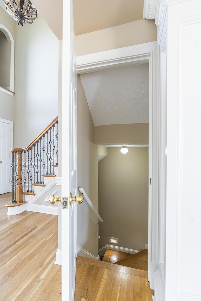 stairway with baseboards and wood finished floors