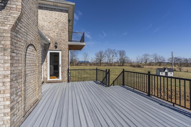 deck with a storage shed, an outdoor structure, and a yard