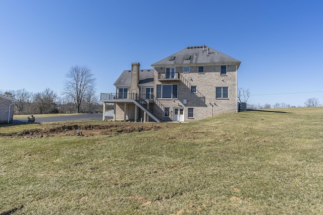 rear view of property with a yard, stairs, and a chimney