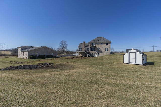 view of yard featuring an outbuilding, a storage unit, and stairs