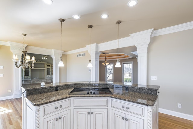 kitchen with light wood-style flooring, black electric stovetop, and crown molding