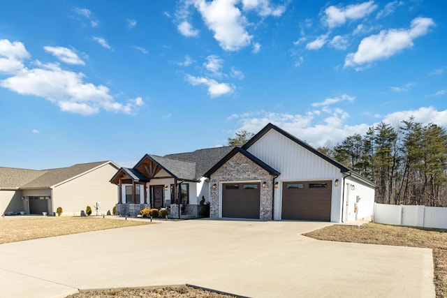 modern inspired farmhouse featuring concrete driveway, fence, and an attached garage