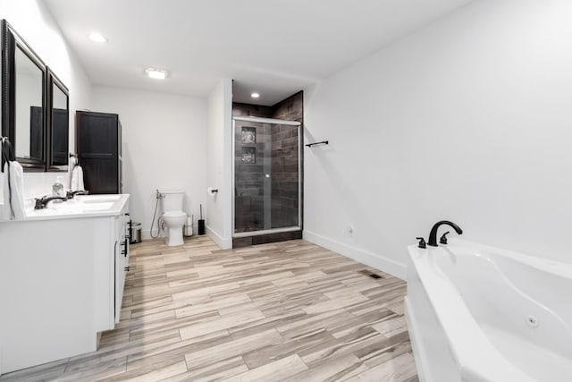 bathroom with toilet, a shower stall, vanity, wood finished floors, and a bath