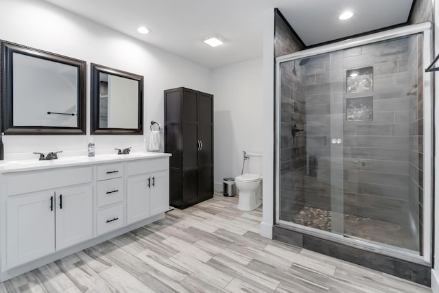 full bath with double vanity, a sink, toilet, and a shower stall