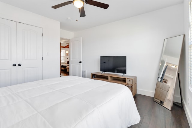 bedroom featuring dark wood-style flooring, visible vents, a ceiling fan, baseboards, and a closet