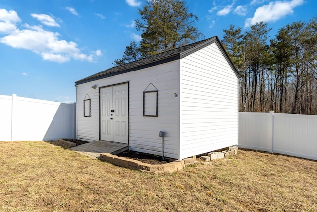 view of outdoor structure with a fenced backyard and an outbuilding