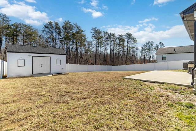 view of yard featuring a patio area, an outdoor structure, and a fenced backyard