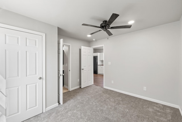 unfurnished bedroom with light carpet, baseboards, ceiling fan, freestanding refrigerator, and recessed lighting