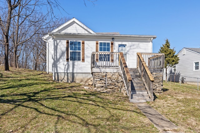 view of front of house featuring stairs, a front lawn, and a deck