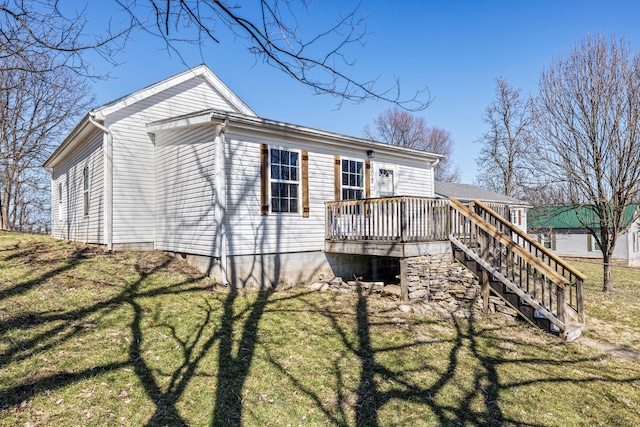 back of property with a yard, stairs, and a wooden deck